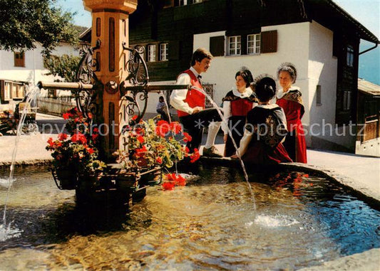 13867049 Brigels GR Trachtengruppe in der Surselva auf dem Dorfplatz Brunnen